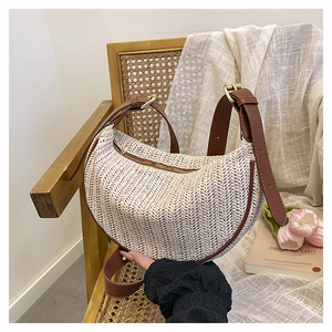 Dettaglio borsa intrecciata con tracolla in pelle marrone e fibbie in metallo oro