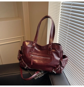 Close-up of deep red tote bag with retro oil leather texture and silver zipper details