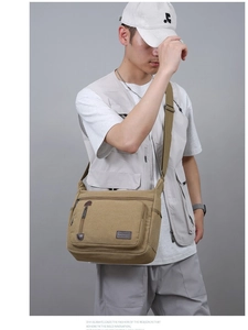 Men's khaki canvas messenger bag with multi-pocket design shown on a casual model