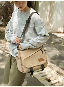 Close-up of khaki crossbody bag with buckled flap and adjustable strap for daily commute