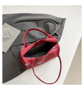 Top view of red lychee grain leather underarm bag with metal rivets and magnetic closure
