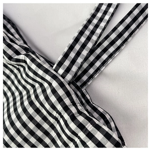 Detail of high-quality stitching on black and white gingham canvas tote bag shoulder strap