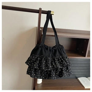 Detalle del bolso floral negro con capas de volantes y estampado de flores amarillas