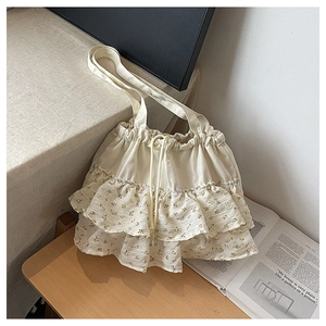 Vista detallada del volante floral y la textura de lona en este bolso con cordón elegante