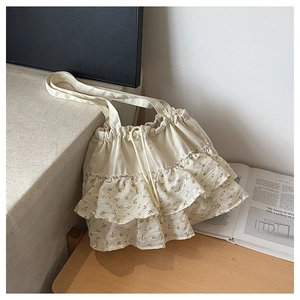 Primer plano de volantes florales crema y textura de gasa en este bolso tote