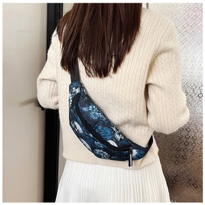 Détail du sac de poitrine à motif tête de mort et fleurs sur mannequin en pull torsadé
