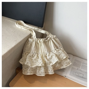Detalle del dobladillo con volantes florales y textura de lona del bolso tote