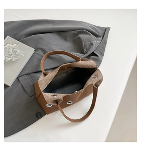 Top-down view of brown leather tote with large metal eyelets and spacious interior
