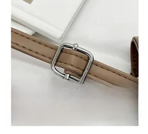 Detail shot of the adjustable brown leather shoulder strap with a silver metal buckle