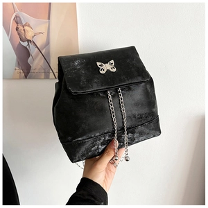 Detail view of black velvet mini backpack with silver butterfly buckle and chain drawstring