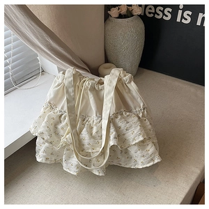 Detalle de volantes florales y tela de lona gruesa en el bolso tote blanco roto