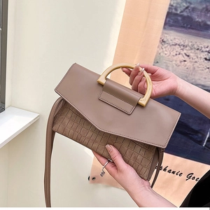 Detail of taupe crocodile-embossed envelope clutch bag with unique semicircular wooden handle