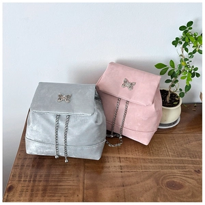 Detail view of mini bow backpacks in silver and pink with metallic butterfly hardware