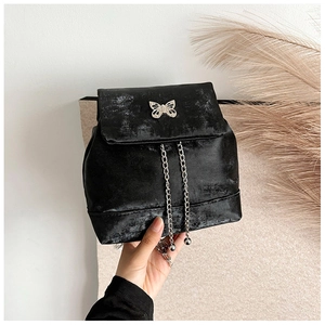 Detail of vintage black mini backpack with silver butterfly buckle and chain tassel