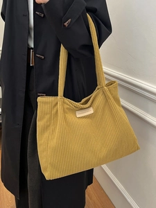 Large capacity mustard yellow corduroy tote bag with fashion label on model