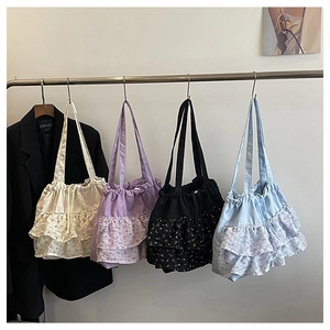 Detalle de cuatro bolsos tote de gasa con estampado floral y bordes de encaje plisado