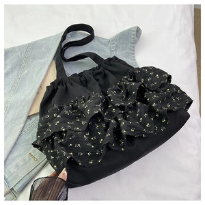 Detalle del bolso tote de gasa negra con volantes de tres capas y estampado de flores