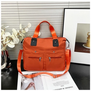 Detailansicht aus hochwertigem orangefarbenem Nylon mit Reißverschlusstaschen und Silberschnalle