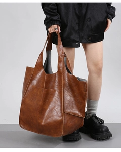 Detail of vintage brown leather tote bag showing soft texture and scalloped edges
