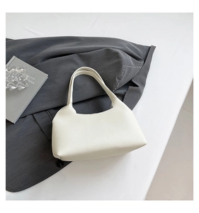 Detailed view of cream-white underarm bag featuring premium lychee grain faux leather texture