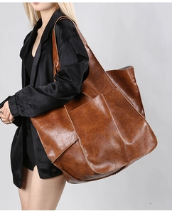 Macro shot of large vintage brown leather tote bag with soft texture and outer pocket