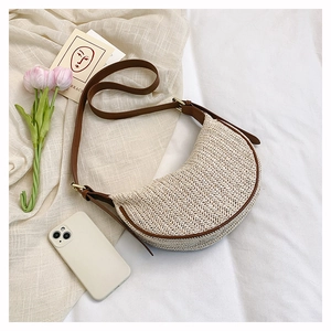 Dettaglio borsa a tracolla intrecciata a spina di pesce beige con finiture in ecopelle marrone