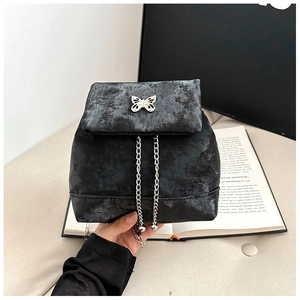 Close-up of black textured mini backpack with silver butterfly buckle and chains
