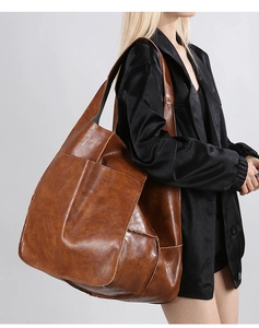 Detailed view of large brown faux leather tote bag showing smooth texture and spacious design
