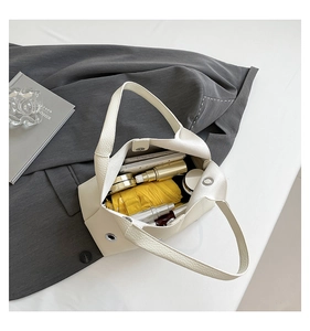 Top view of cream rivet hollow bucket bag showing spacious interior with daily essentials