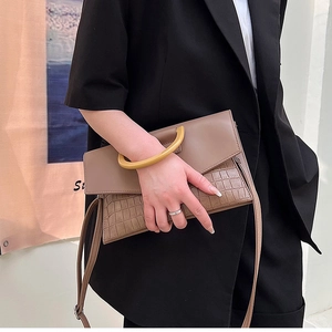 Detail of coffee crocodile pattern handbag with yellow resin handle and shoulder strap