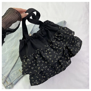 Detalle del bolso tote floral negro con volantes y delicadas flores amarillas