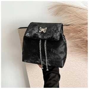 Detail of black mini backpack with metallic butterfly ornament and silver chains