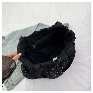 Vista de detalle del bolso tote floral negro con compartimento y cremallera metal
