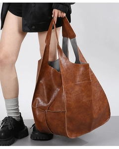 Detail of vintage brown soft leather tote bag showing stitching and large front pocket