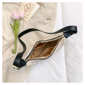 Dettaglio della borsa a tracolla intrecciata a righe beige con cinturino in pelle e tasche
