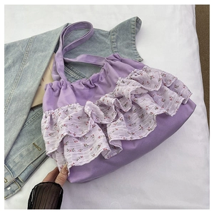 Detalle del bolso tote de lona morada con volantes de malla floral y correas resistentes