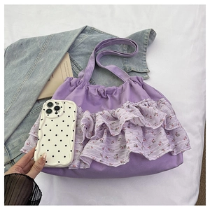 Detalle del bolso tote morado con volantes florales y textura de gasa en capas suaves
