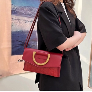 Macro view of red crocodile texture leather bag with elegant gold D-shaped buckle