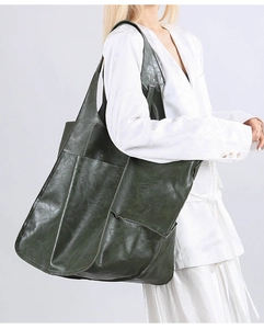 Detail of soft dark green leather tote bag with wide strap for daily shoulder wear