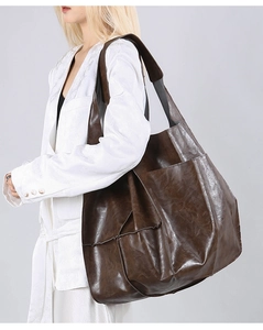 Detail of vintage brown tote bag with wrinkled texture and wide strap on model