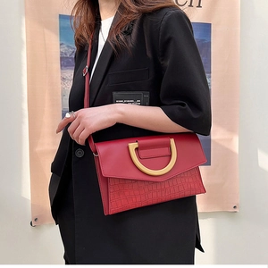 Detailed view of dark red crocodile textured flap bag with a golden D-shaped buckle