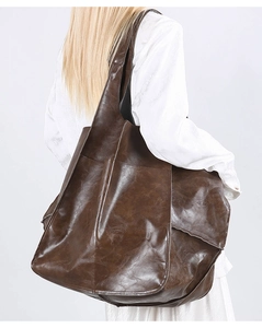 Back view of a large vintage brown soft leather tote bag on model's shoulder