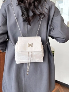 Mini velvet backpack in off-white with gold butterfly buckle and silver chain strap