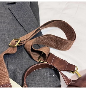 Close-up of adjustable woven canvas strap and leather connector with retro metal buckle