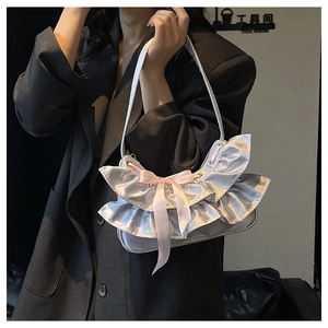 Detail of silver satin shoulder bag featuring pink ribbon bow and ruffled balletcore design