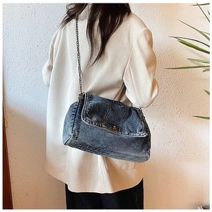 Seitenansicht einer Vintage-Nieten-Jeans-Umhängetasche mit Kettenriemen am Model