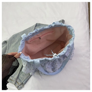 Detalle del interior del bolso floral con forro rosa y práctico cierre de cordón