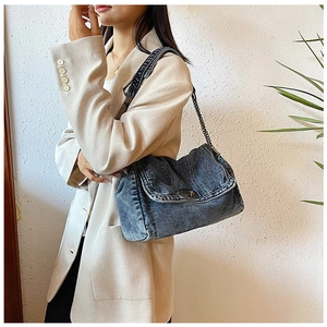 Detail der verzierten Denim-Umhängetasche mit Vintage-Waschung und Metall-Kettenriemen
