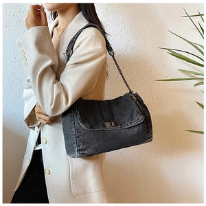 Detailaufnahme der Vintage-Umhängetasche aus gewaschenem Denim mit Nieten und Kette