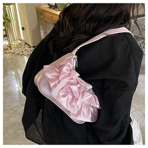 Detailed view of a pink satin shoulder bag with ruffles and bow in a sweet Korean style